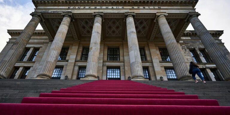 a man walking up a set of stairs in front of a building