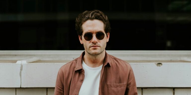 man standing in front of white concrete wall