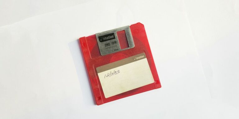 red and white floppy disk on white surface