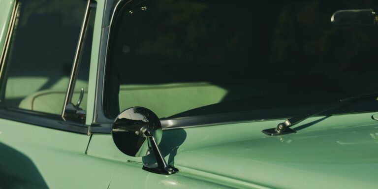 a close up of the side mirror of a green car