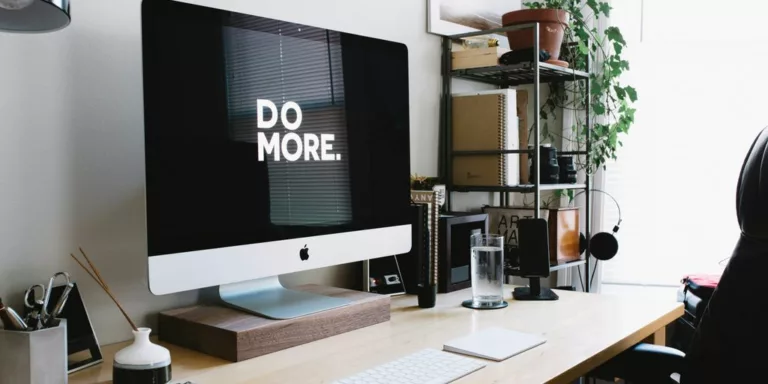 silver iMac with keyboard and trackpad inside room