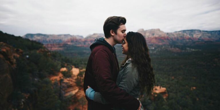 man kissing woman's forehead