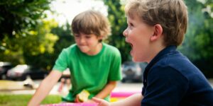 boy in blue shirt screaming near boy in green crew-neck shirt