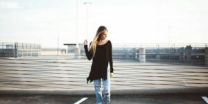 woman standing on gray concrete pavement