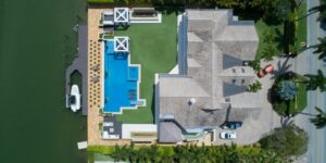 bird's eye view of house with pool near body of water