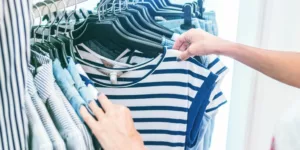 person holding white and black striped shirt