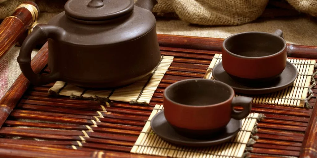 a tray with three cups and a teapot on it