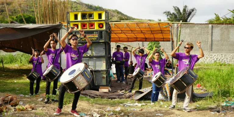 A group of people in purple shirts playing drums