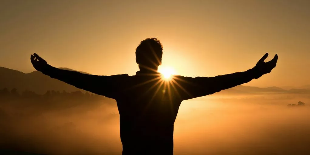 silhouette photo of man on cliff during sunset