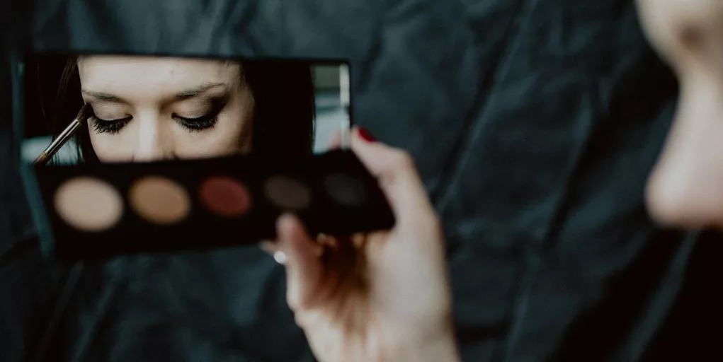 woman holding black and silver make up palette