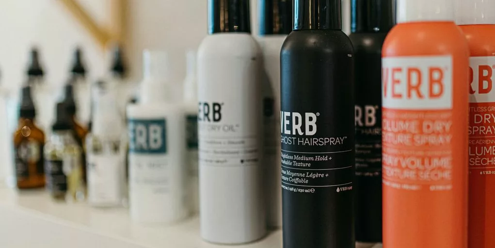 a white shelf topped with lots of different types of hair products