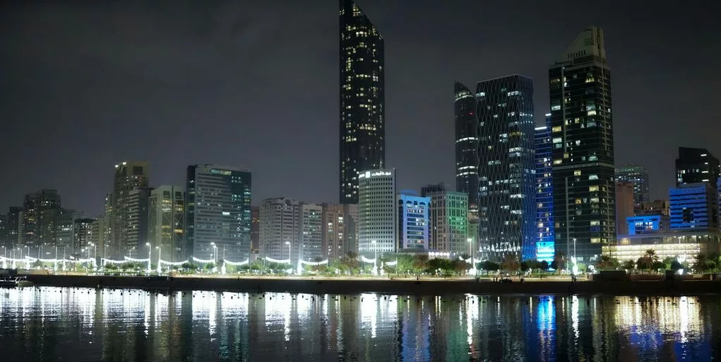 a city at night with lights reflecting in the water