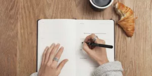 person writing on a book