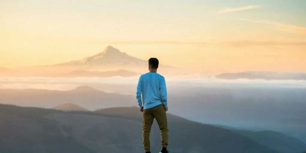 man standing on top of mountain