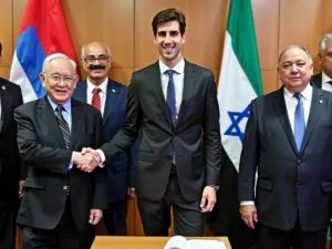 Kushner with UAE and Israeli officials shaking hands.