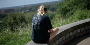 woman in black t-shirt sitting on concrete bench during daytime