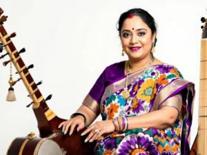 Shubha Mudgal in traditional attire with musical instruments.