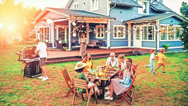 Big Family and Friends Celebrating Outside at Home. Diverse Group of Children, Adults and Old People Gathered at a Table, Having Fun Conversations. Preparing Barbecue and Eating Vegetables.