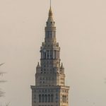 A very tall building with a clock on it's side