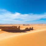 Desert landscape with ancient ruins, clear sky.