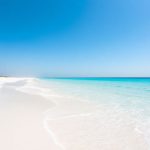 Sunny UAE beach, azure water, white sand, clear sky.