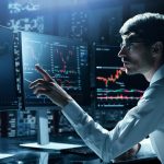 financial analyst pointing at the computer monitor .