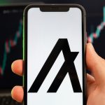 Algorand ALGO app of cryptocurrency stock market analysis on the screen of mobile phone in man hands and growing charts trading data on the background, February 2022, San Francisco, USA