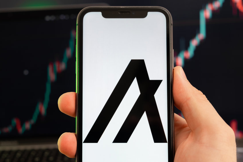 Algorand ALGO app of cryptocurrency stock market analysis on the screen of mobile phone in man hands and growing charts trading data on the background, February 2022, San Francisco, USA